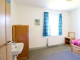 A bedroom with a bed and a sink at Clwyd Special Riding Centre Llanfynydd