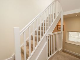 A staircase with a handrail and window at Swirl Howe in Keswick