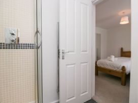 A bathroom with a shower and adjacent bedroom at Swirl Howe in Keswick
