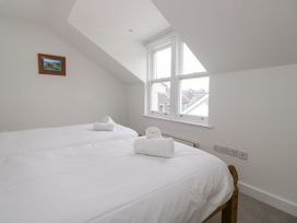 A bedroom with two beds and a window at Swirl Howe in Keswick