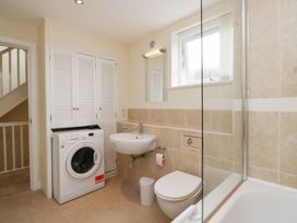 A bathroom featuring a washing machine, sink, toilet, and shower at Swirl Howe in Keswick