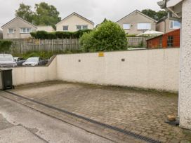 A paved area with a garbage bin and cars in the background at Swirl Howe in Keswick