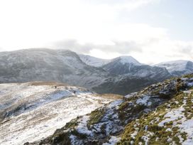 A scenic view of mountains and hikers on a trail at Swirl Howe in Keswick