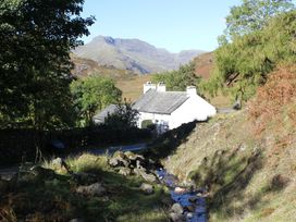 A house near a stream with mountains in the background at Swirl Howe Keswick