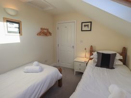 A bedroom with two beds and a wardrobe at Swirl Howe in Keswick