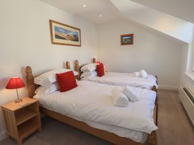 A bedroom with two beds and a lamp at Swirl Howe in Keswick