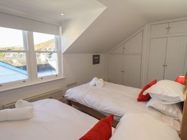A bedroom with two beds and a wardrobe at Swirl Howe in Keswick