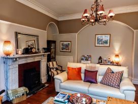 A living room with a fireplace, a couch, and a coffee table at 1 Park Road in Windermere