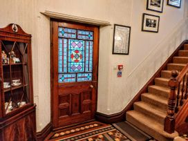 An entrance hall with a stained glass door and staircase at 1 Park Road Windermere