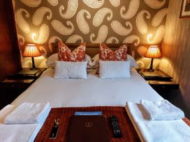 A bedroom with a bed, pillows, nightstands and lamps at 1 Park Road, Windermere