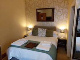 A bedroom with a bed and nightstands at 1 Park Road, Windermere