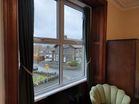 A window with curtains overlooking a road at 1 Park Road in Windermere