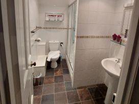 A bathroom with a shower, sink, and toilet at 1 Park Road in Windermere