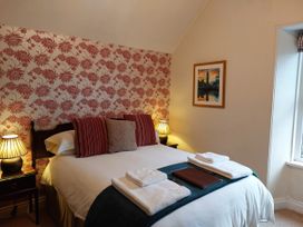 A bedroom with a bed, pillows, and lamps at 1 Park Road in Windermere