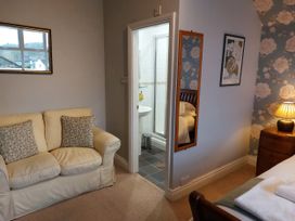 A bedroom with a sofa and adjacent bathroom at 1 Park Road in Windermere