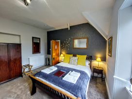 A bedroom with a bed and furniture at 1 Park Road in Windermere