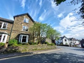 A stone house with trees and garden along the road at 1 Park Road Windermere