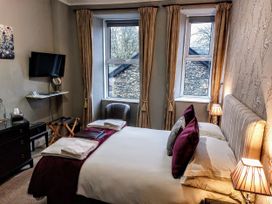 A bedroom with a bed and television at 1 Park Road Windermere