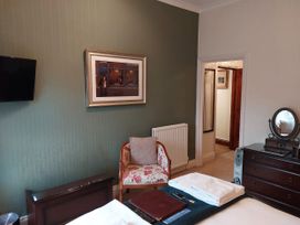 A bedroom with a chair and television at 1 Park Road in Windermere
