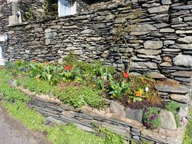 A garden bed with flowers beside a stone wall at 1 Park Road Windermere