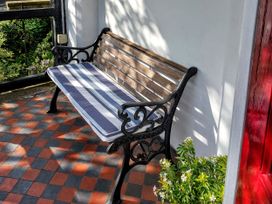 A bench with a cushion and flowers at 1 Park Road in Windermere