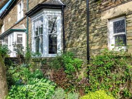 An outdoor area with a stone wall and plants at 1 Park Road Windermere