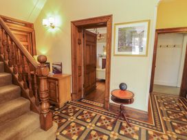 A hallway with a staircase and decorative floor tiles at 1 Park Road Windermere