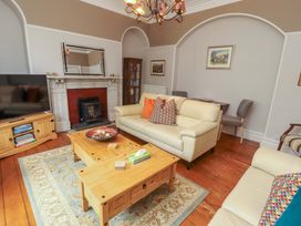 A living room with a sofa, coffee table, and television at 1 Park Road Windermere