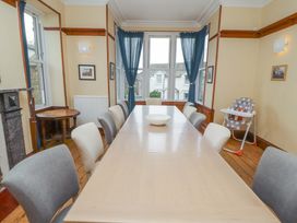 A dining room with a long table and chairs at 1 Park Road in Windermere