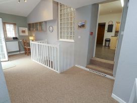 A hallway with a staircase and clock at 1 Park Road in Windermere