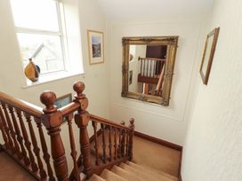 A staircase with a mirror and artwork at 1 Park Road Windermere