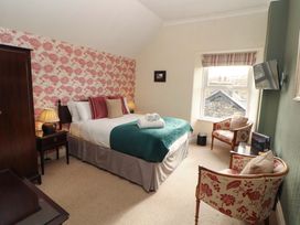 A bedroom with a bed and a chair at 1 Park Road Windermere