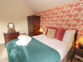 A bedroom with a bed and side tables at 1 Park Road in Windermere