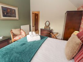 A bedroom with a bed and a chair at 1 Park Road in Windermere