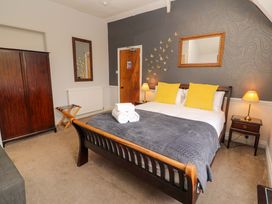 A bedroom with a double bed and wooden furniture at 1 Park Road in Windermere