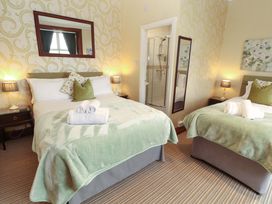 A bedroom with two beds and a shower at 1 Park Road in Windermere