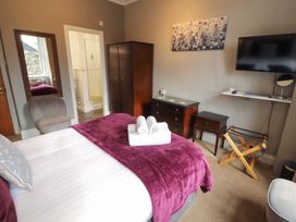 A bedroom with a bed and towels at 1 Park Road in Windermere