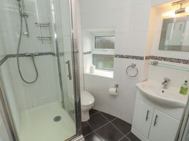 A bathroom featuring a shower, toilet, and sink at 1 Park Road in Windermere