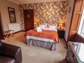 A bedroom with a bed and furniture at 1 Park Road in Windermere