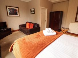 A bedroom with a bed and couch at 1 Park Road in Windermere