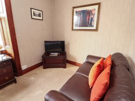 A living room with a sofa and television at 1 Park Road Windermere