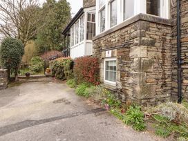 A house with a stone wall and bushes at 1 Park Road in Windermere