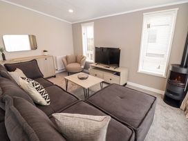 A living room with a sofa, coffee table, and television at Dolphin in Haverfordwest