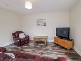 A living room with a recliner chair and television at Teac Caoimhe in Falcarragh