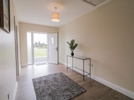 A hallway with a door and a console table at Teac Caoimhe in Falcarragh