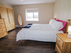 A bedroom with two beds and a wardrobe at Teac Caoimhe in Falcarragh