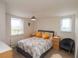 A bedroom with a bed and two windows at Larpool Retreat