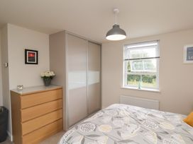 A bedroom with a bed, wardrobe, and window at Larpool Retreat 