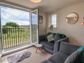 A living room with a sofa and a balcony at Larpool Retreat in Whitby