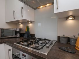 A kitchen featuring a gas stove and microwave at Larpool Retreat Whitby